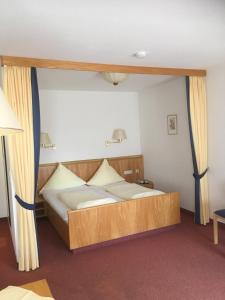 ein Schlafzimmer mit einem großen Bett mit einem Holzrahmen in der Unterkunft Appartement Hotel Finkenhof in Kirchham