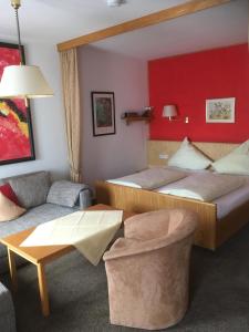 ein Hotelzimmer mit 2 Betten und einem Sofa in der Unterkunft Appartement Hotel Finkenhof in Kirchham