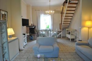 a living room with a blue chair and a staircase at L'Altalena in Mommio