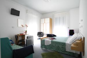 een slaapkamer met een bed, een bureau en een stoel bij Hotel Capri in Bellaria-Igea Marina