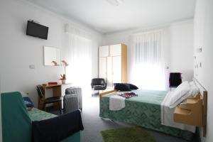 a bedroom with a bed and a desk and a chair at Hotel Capri in Bellaria-Igea Marina