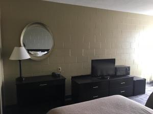 1 dormitorio con espejo y tocador con TV en Sunlac Inn Lakota, en Lakota