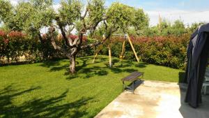 ヴァストにあるLa casa del Contadinoの木とブランコのある庭のベンチ