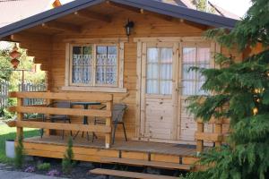 une cabine en bois avec une table et des chaises sur une terrasse dans l'établissement Willa Sara, à Ustka