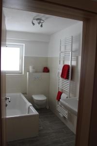 a bathroom with a tub and a toilet and a sink at Haus Alpina in Berwang