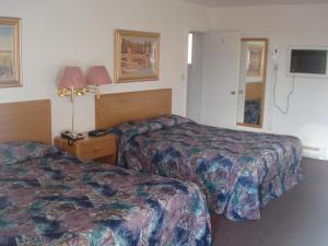 um quarto de hotel com duas camas e uma televisão em Satelite Motel em Sault Ste. Marie