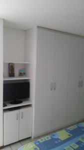 sala de estar con armarios blancos y TV en RESORT ANCORAR FLAT 6102, en Porto de Galinhas