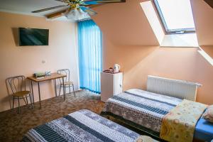 sypialnia z 2 łóżkami, stołem i oknem w obiekcie Usługi Hotelarskie Małgosia i Andrzej Danowski w mieście Grajewo