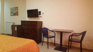sypialnia z łóżkiem, biurkiem i telewizorem w obiekcie Hotel La Vela w mieście Boscoreale