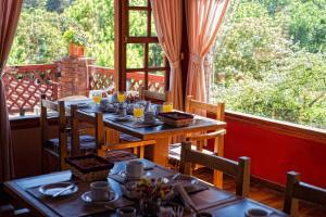 a dining room with tables and chairs and a large window at Cabañas del Golf in La Cumbre