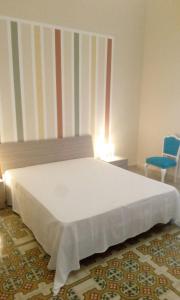 トラッペートにあるRosa dei Ventiのベッドルーム(白いベッド1台、青い椅子付)