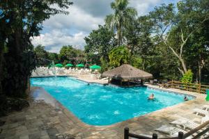 uma piscina num resort com pessoas em Ecoresort Refúgio Cheiro de Mato em Mairiporã