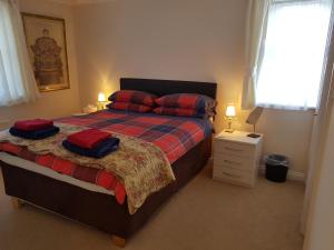 a bedroom with a bed with red pillows on it at 1 Derby Court Castletown in Castletown