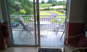 an open door to a balcony with a table and chairs at DunnCourt House in Killarney