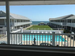 a view of a pool from a balcony of a resort at The Three Seasons Resort in Dennis Port +9 photos