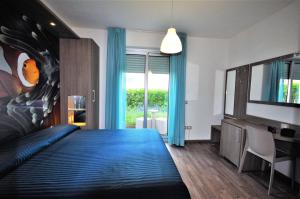 una camera con letto blu e televisore di Hotel Miramare a Pineto