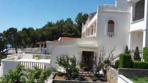 a white house with a garden in front of it at Guest house Fenix Brela in Brela