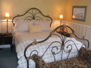 a bedroom with a large bed and a chair at Rothesay House Heritage Inn B&B in Harbour Grace