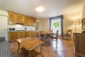 グラードにあるResidence Villa Marinaのテーブルと椅子のあるキッチンとリビングルーム