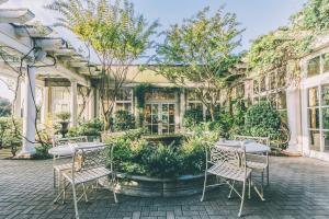 un patio con mesas, sillas y una fuente en O.Henry Hotel en Greensboro