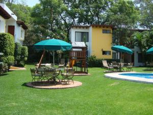 a group of chairs and umbrellas next to a pool at Hotel Vista Hermosa in Cuernavaca