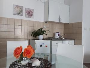una cocina con una mesa con un jarrón de flores. en Studios Adriatic en Herceg-Novi