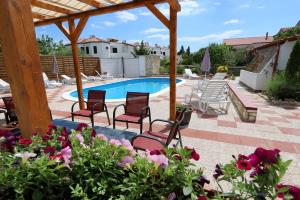 a patio with chairs and a swimming pool at Pansion Comfort Sidro in Novalja