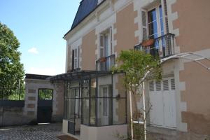 a building with a door and a tree in front of it at Lit en Loire in Saint-Cyr-sur-Loire