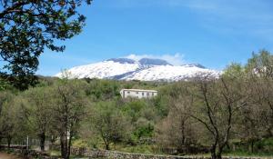 a snow covered mountain with a house in the foreground at Boscoscuro in Ragalna