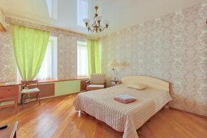 a bedroom with a bed and a chair and a desk at Apartments at Kazanskaya 9 in Saint Petersburg