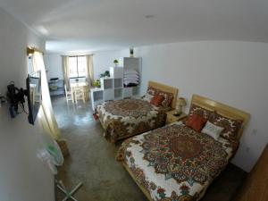 ein Schlafzimmer mit 2 Betten und ein Wohnzimmer in der Unterkunft Hospedaje El Mezquite in Tequisquiapan