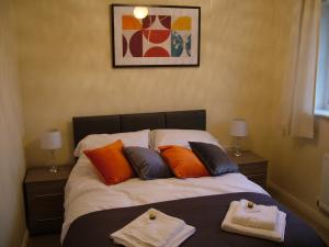 a bedroom with a bed with two towels on it at Thistle Cottage in Mildenhall