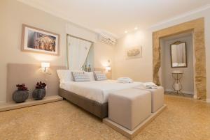 1 dormitorio con 1 cama blanca grande y 2 jarrones en Palazzo Taranto Luxury Rooms, en Caltagirone