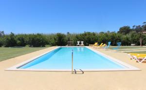 a large swimming pool with lounge chairs at Casa Das Romãs in Moncarapacho