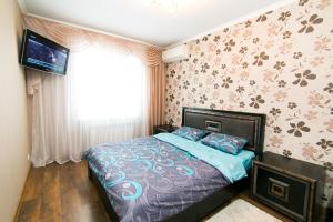 Schlafzimmer mit einem Bett und einem TV an der Wand in der Unterkunft VIP Apartment on Ilinska in Sumy