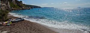 a group of people laying on a beach next to the water at Buena Vis-ta Apartments with the Sea View in Vis