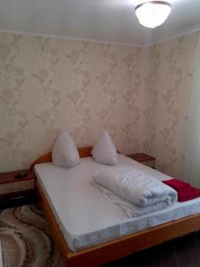 een kleine slaapkamer met een bed met witte lakens bij Hotel Dubrava in Poltava +49 foto's