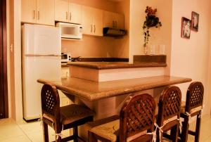 a kitchen with a counter with chairs and a refrigerator at Spectacular Ocean View Apartment in Punta Blanca