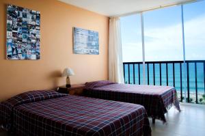 a hotel room with two beds and a balcony at Spectacular Ocean View Apartment in Punta Blanca