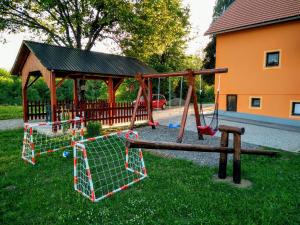a playground with a swing set and a wooden pavilion at House Naomi in Grabovac