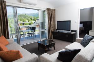 a living room with a couch and a flat screen tv at Clear Ridge Apartments in Hanmer Springs