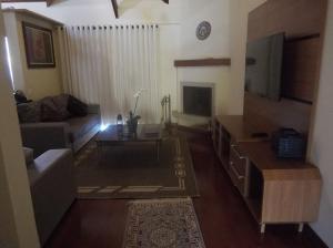 a living room with a couch and a tv at Caluan Apartment in Monte Verde