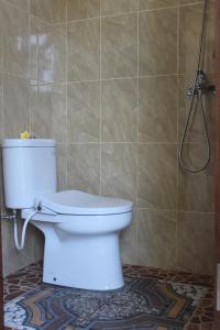 y baño con aseo blanco y ducha. en Sila Urip Guest House, en Ubud
