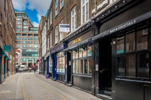 an empty street in a city with buildings at Square Mile Residences in London