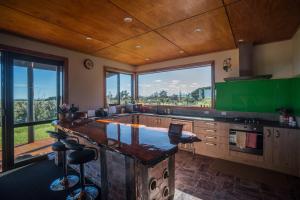 a kitchen with a large island with a green counter top at Koru Beachfront Holiday Cabins & Hot Tub in Barrytown