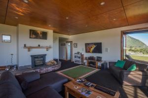 a living room with a couch and a fireplace at Koru Beachfront Holiday Cabins & Hot Tub in Barrytown