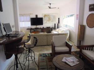 a living room with a couch and a table and chairs at Pousada Náutilus in Ilhabela