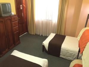 a hotel room with two beds and a tv at Hotel Betania in Zamora
