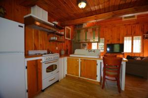uma cozinha com um fogão branco e um frigorífico branco em La Sapinette em Val-David