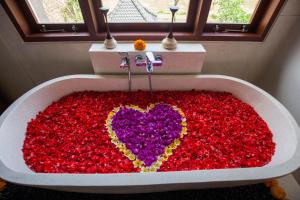 een bad gevuld met een hart gemaakt van bloemen bij Alosta Luxury Private Villa in Ubud +49 foto's